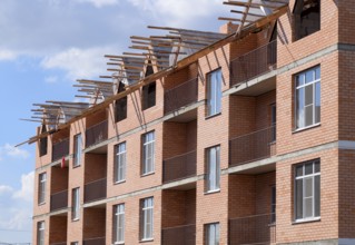A three-storey brick apartment building under construction. Atyrau, Kazakhstan