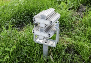 Streetlight illuminator is installed on the lawn. Atyrau, Kazakhstan