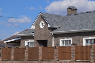 Asphalt shingle. Decorative bitumen shingles on the roof of a brick house. Atyrau, Kazakhstan