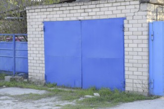 Garage with blue iron gates. Atyrau, Kazakhstan