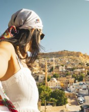 Traveler woman in white dress arms taking selfie self-portrait ooking over panoramic view of
