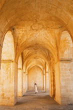 Kasimiye Medrese stone arches with traveler in white dress, iconic historic landmark in Mardin,