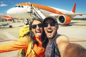 Young happy caucasian couple taking selfie portrait on departure or arrival destination for