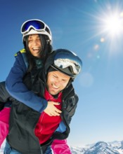 Romantic happy skiers couple in love having fun together playing in mountains piggybacking at