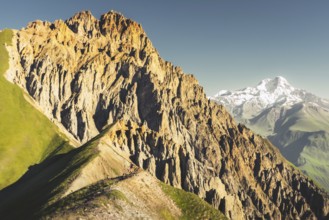 Hiker on ridge explore Kazbegi National Park in Georgia with dramatic rocky peak view Kabarjina