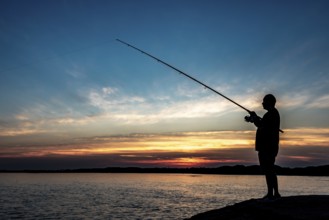 Silhouette Of A Fisherman With His Pole At The Atlantic Coast Of Wales, United Kingdom