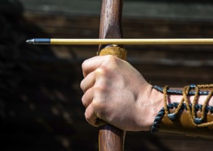 Hand Of An Archer Holds Bow And Arrow To Aim At Target, Austria
