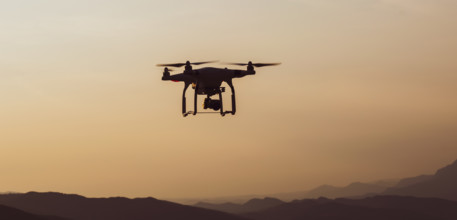 Quadcopter in the air with mountains landscape in a countryside of Slovenia