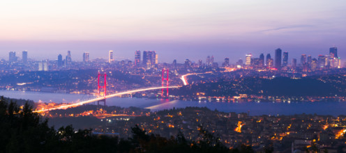 View from Camlica hill to 15 July Martyrs bridge with scyscrapers in the background after sunset