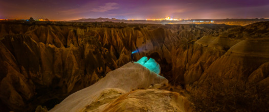 Cappadocia rose valley with male person at night posing. Turkey