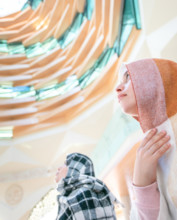 Muslim young millenial girls with scarfs during the pray in modern Marmara mosque in Istanbul.