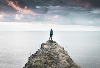 Male person standing on edge of Tsikhisdziri fortress ruins in Tsikhisdziri village in Georgia with