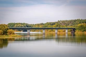 Bridge over a quiet reservoir with wooded shores and clear skies, Zeulenrodaer Meer reservoir,