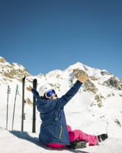 Young happy caucasian woman pose with skis arms outstretched in high mountains. Get away skiing