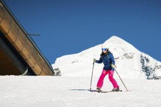 Young caucasian woman beginner skier on slope learn enjoy ski downhill in beautiful sunny day with