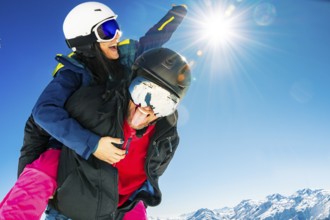 Romantic happy skiers couple in love having fun together playing in mountains piggybacking at