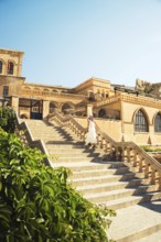 Traveler woman in white dress walking stairs of historic building - visit Mardin museum in old city