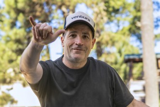 Surfer in a cap making a hang loose gesture