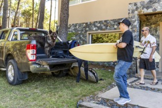 Men and a dog getting ready for a surf trip