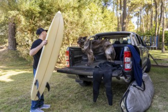 Man and his dog getting ready for a surf trip