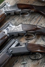 Details Of Open Hunting Rifles Laying On Wooden Table