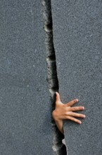 Hand Of A Child Grasps Through Narrow Gap In Marble Wall