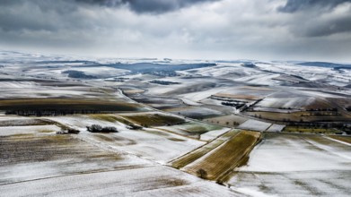 Aerial View Of Agricultural Winter Landscape With Remote Settlements And Snow Covered Fields In