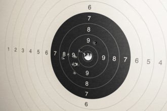 Hitmarks And Spot-On Hit On Round Paper Target With Bullet Holes From Shooting Training