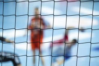 The net behind the goal and silhouette of handball players in the background. Lubin, Poland