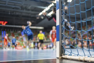 Detail of handball goal post with net and handball match in the background. handball match. Lubin,
