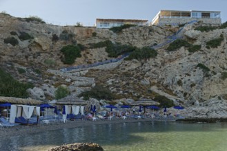 Secluded Grande Blue Beach with blue parasols and clear sea water, Grande Blue Beach, Stegna,