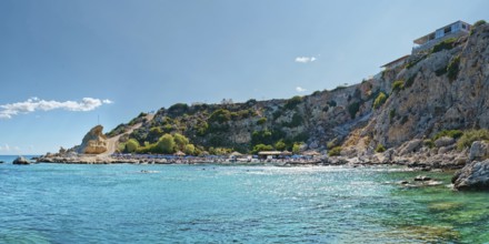 Grande Blue Beach with blue sea, rocky cliffs and a house under a clear sky, Grande Blue Beach,