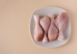 Chicken legs on a plate ready for cooking broth, copy space