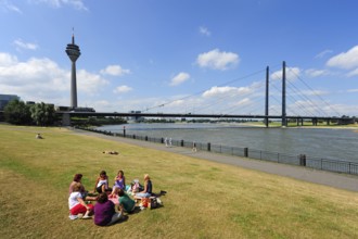 Ladies picnic on the Rhine promenade, view of the Rhine Tower, TV Tower, and Rheinknie Bridge,