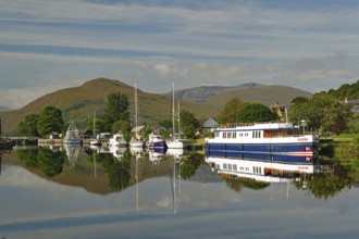 Harbour with boats and reflections under the surrounding green mountains, Caledonian Canal,