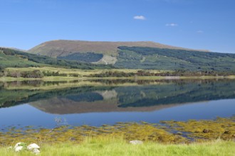 A loch with a clear reflection of mountains under a bright blue sky, Loch Eil, Scotland, Great