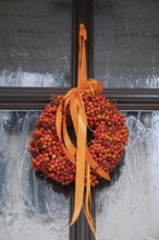 Door wreath made from orange rowanberries, Hesse, Germany
