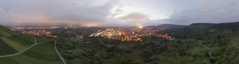 Dusk over an illuminated town, surrounded by vineyards and orchards, Korb and Kleinheppach in the