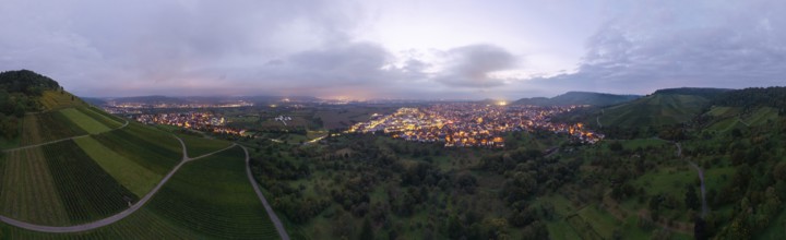 Dusk over an illuminated town, surrounded by vineyards and orchards, Korb and Kleinheppach in the