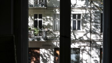 View through a window to an opposite facade of a multi-storey residential building with classical