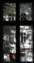 View through a window to an opposite facade of a multi-storey residential building with classical