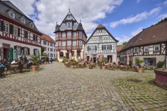 Old town, historic half-timbered houses, cobblestone square, outdoor area of a restaurant, visitors