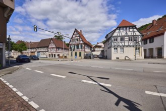 Half-timbered houses, pointed roof with red roof tiles, traffic lights, streets, vehicles, blue