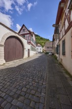 Old town, alley, historic half-timbered houses, wall, access gate, blue sky, cumulus clouds,