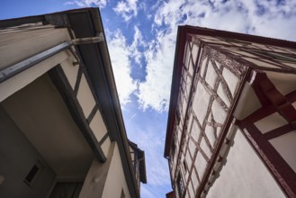 Old town, half-timbered houses, facade with downpipe, steep frog perspective, blue sky, cumulus