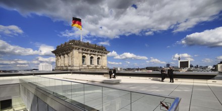 Roof terrace with a German flag in the wind on one of the corner towers of the Reichstag building,