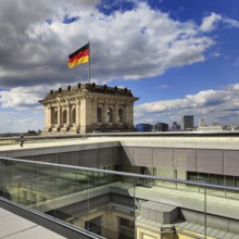 Viewing platform with a German flag in the wind on one of the corner towers of the Reichstag