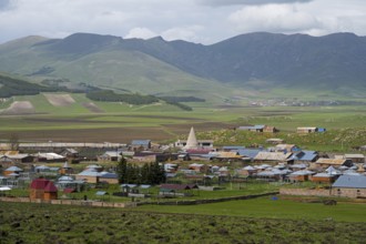 A small village in a green mountain landscape with scattered houses and fields, Yazidi temple, Rya