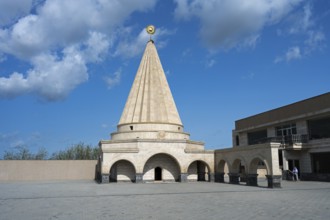 A large stone mausoleum with a dome against a clear blue sky, Yazidi temple, Shekhubekir,