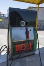 An old diesel pump at a petrol station with a large sign, diesel fuel pump, petrol station, petrol